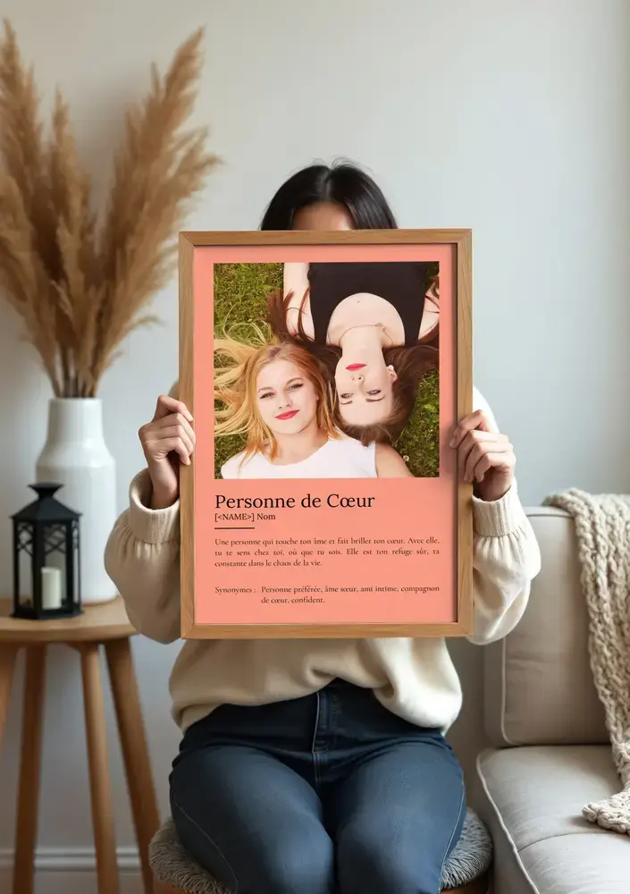 Affiche avec définition et photo de deux amies sur fond saumon, présentée dans un cadre en bois clair au salon