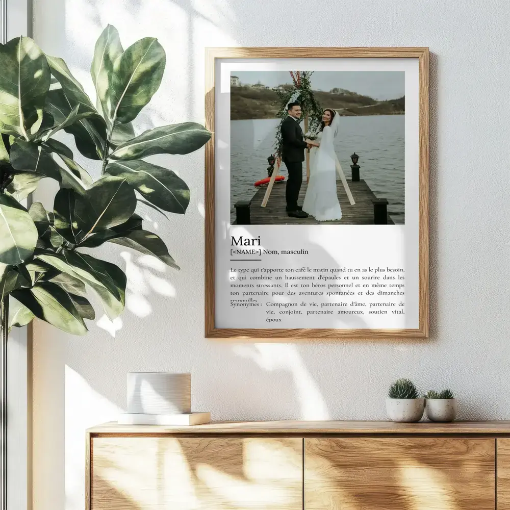 Affiche définition du mari avec photo de mariage, encadrée en bois au mur au-dessus d’un buffet.