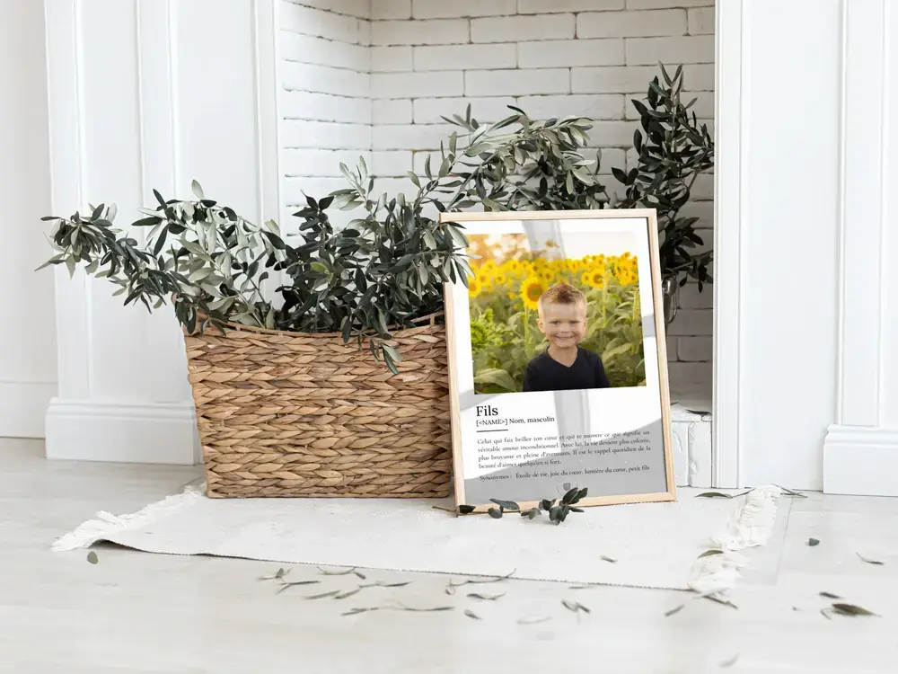 Affiche définition avec photo d’enfant, cadre en bois clair posé au sol près d’un panier de plantes