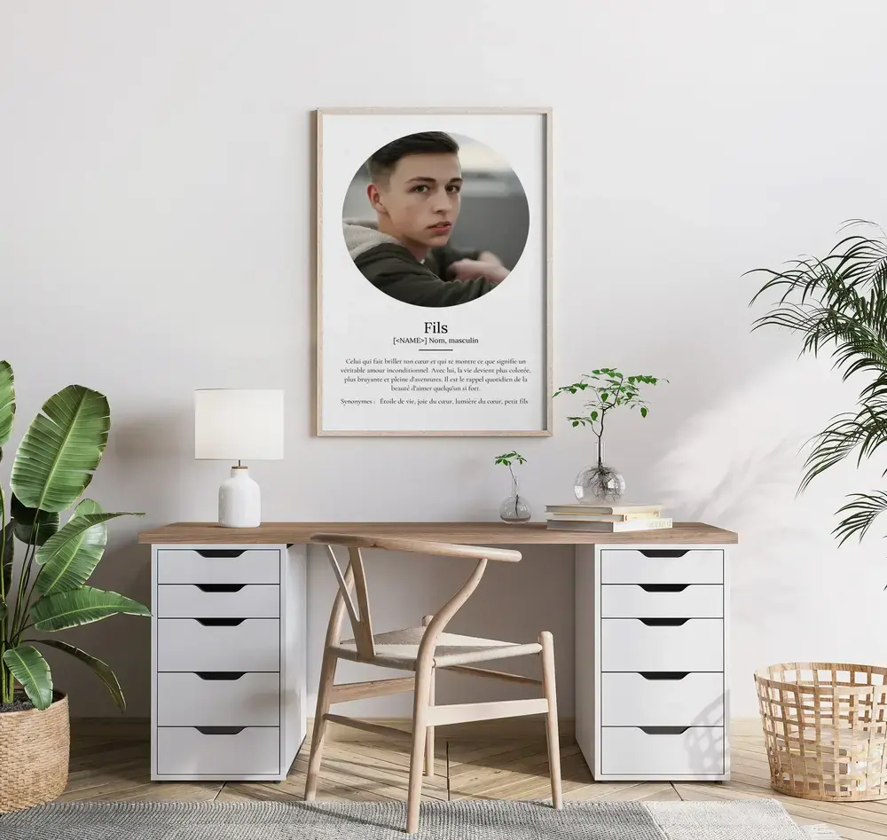 Affiche définition avec portrait rond sur fond blanc, encadrée en bois clair au-dessus d’un bureau