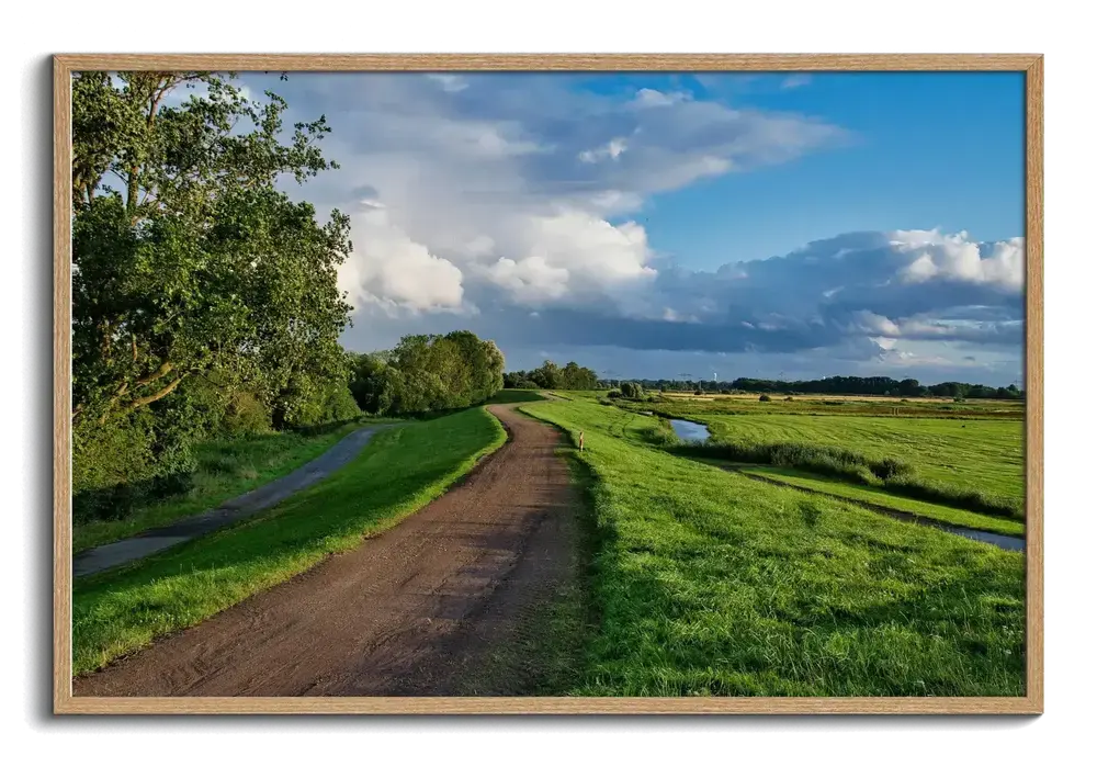 Photo sur plexiglas avec chemin de campagne et prairies verdoyantes, encadrée en bois naturel