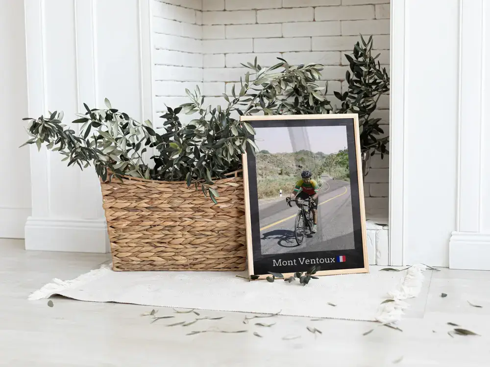 Photo de cyclisme encadrée avec lieu, posée au sol près d'une plante, une idée cadeau pour cycliste