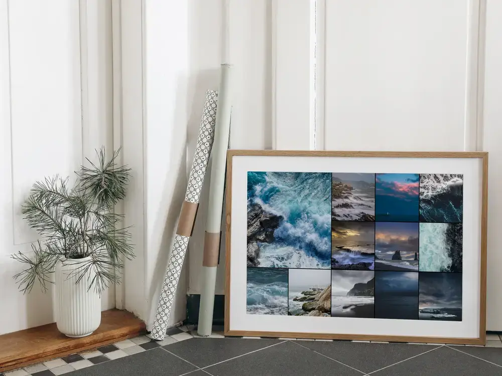 Pêle-mêle photo de mer agitée, encadré en bois naturel avec passe-partout blanc, posé au sol contre un mur
