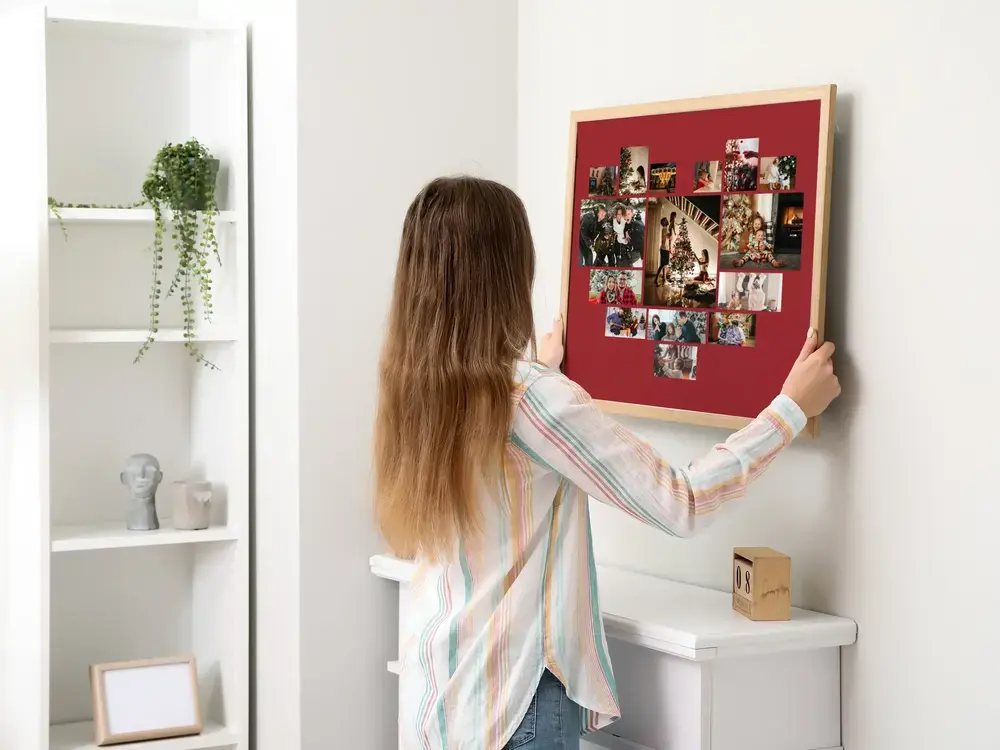 Collage photo en cœur sur fond rouge foncé, encadré au mur, une idée cadeau de Noël pour les proches