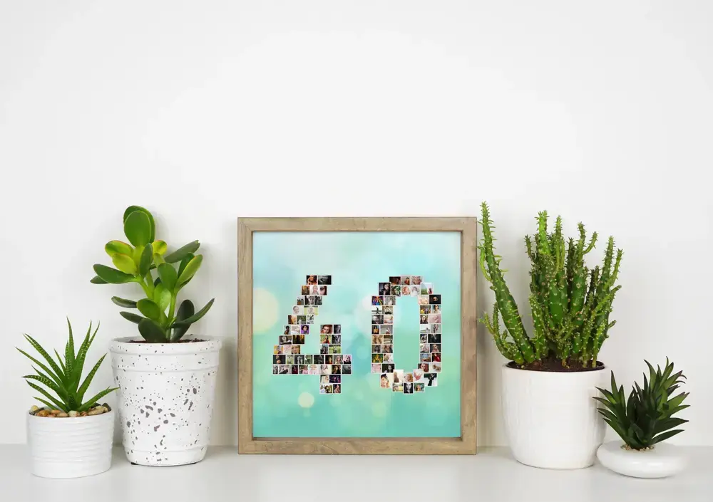 Collage photo en forme de 40 sur fond turquoise, encadré en bois sur un bureau blanc entre des plantes